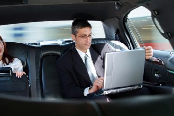 Assistant and Executive sitting in the back of a limousine