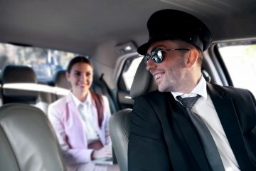 Chauffeur speaking to client in back seat of limousine