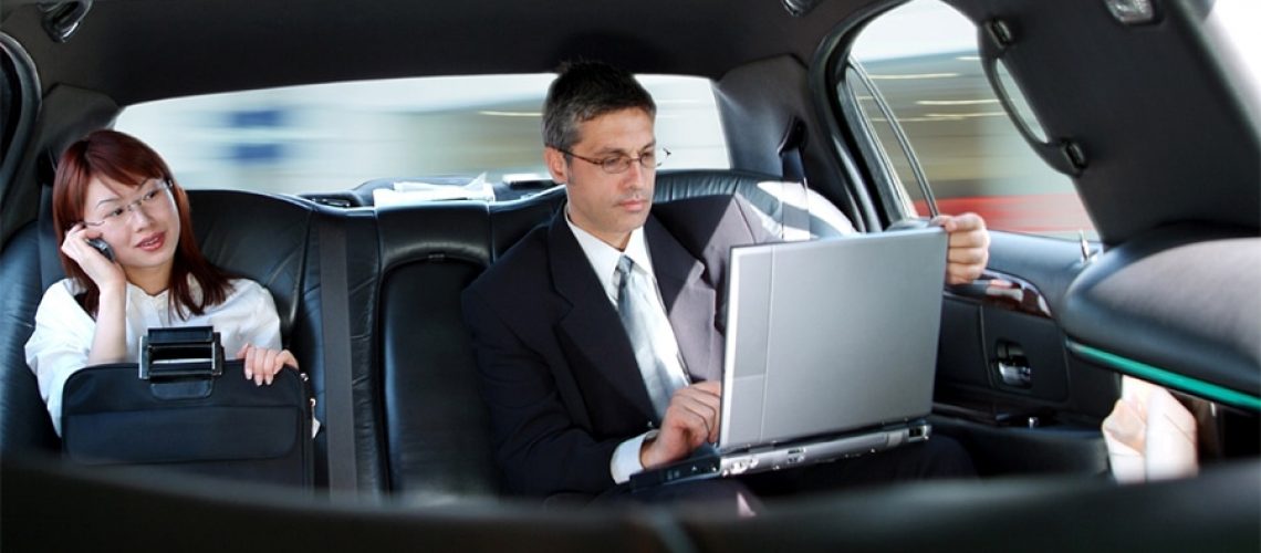 Assistant and Executive sitting in the back of a limousine